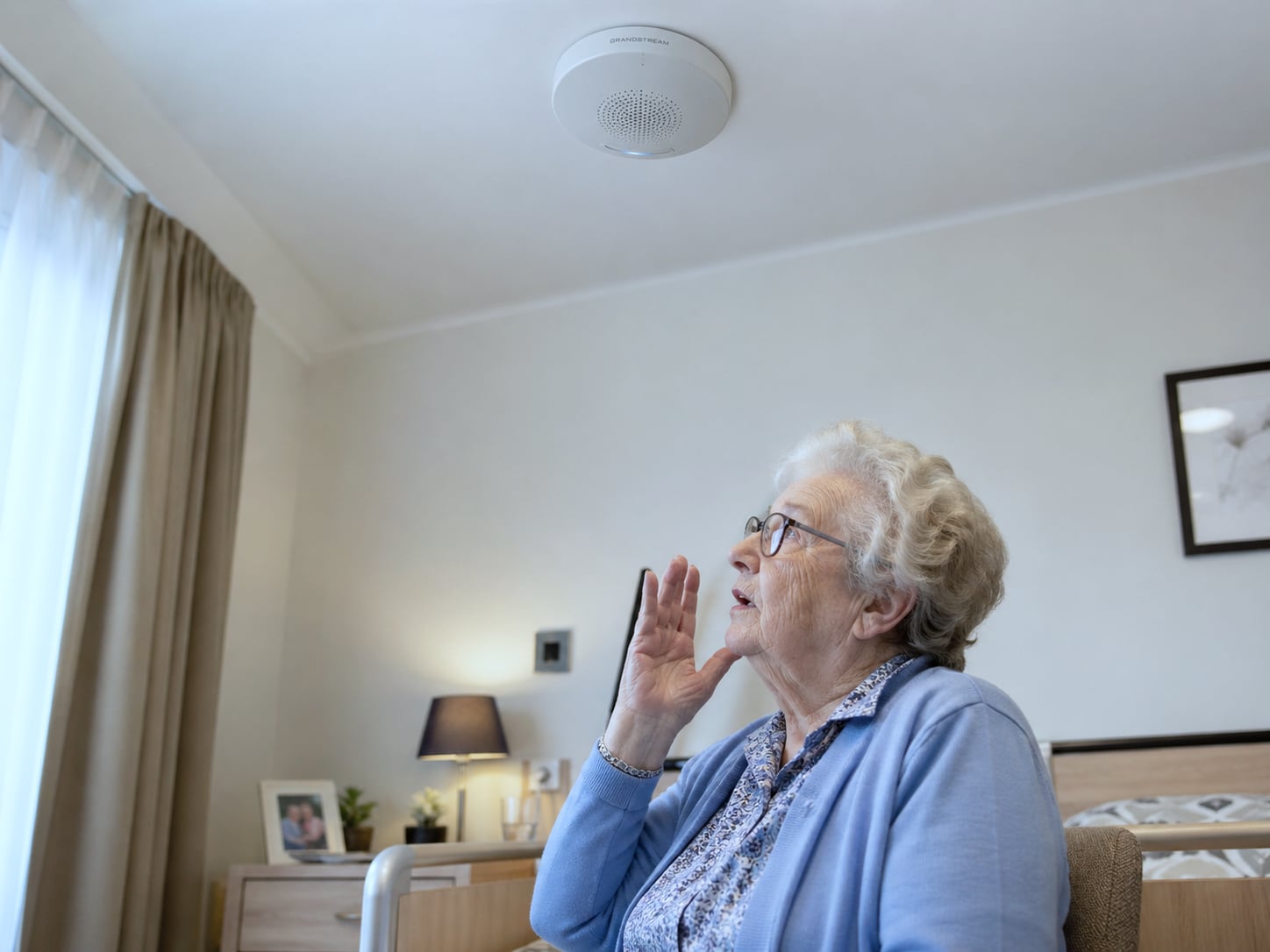 Care worker in navy polo answering an intercom call on a professional Android smartphone at the entrance of a Belgian care home, visitor identified at the door, Healthcall installation